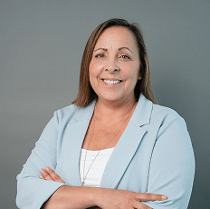 Headshot of a smiling woman wearing a light blue blazer.