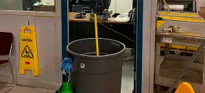 Commercial cleaning supplies and caution sign in a workplace