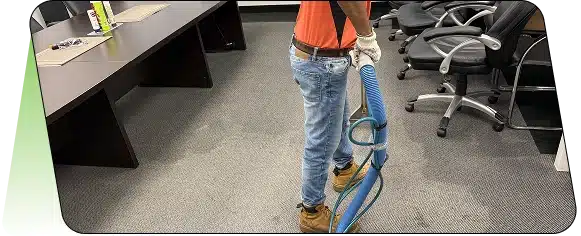 A blue floor buffing machine on a wet tiled floor with a yellow power cord.
