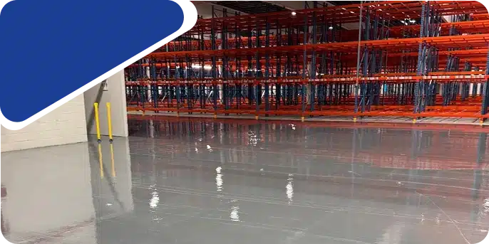 Empty red metal shelving units in an industrial warehouse setting.