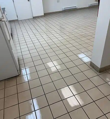 A clean hallway with shiny, light-colored square floor tiles.