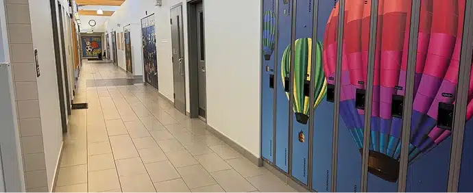 A brightly lit hallway with colorful patterned lockers along the wall.